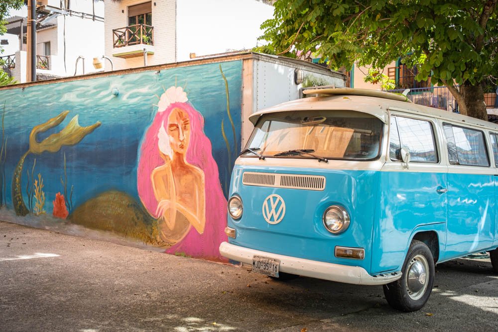 VW bus with surfboard and art mural in Sayulita Mexico on surf retreat and destination travel guides