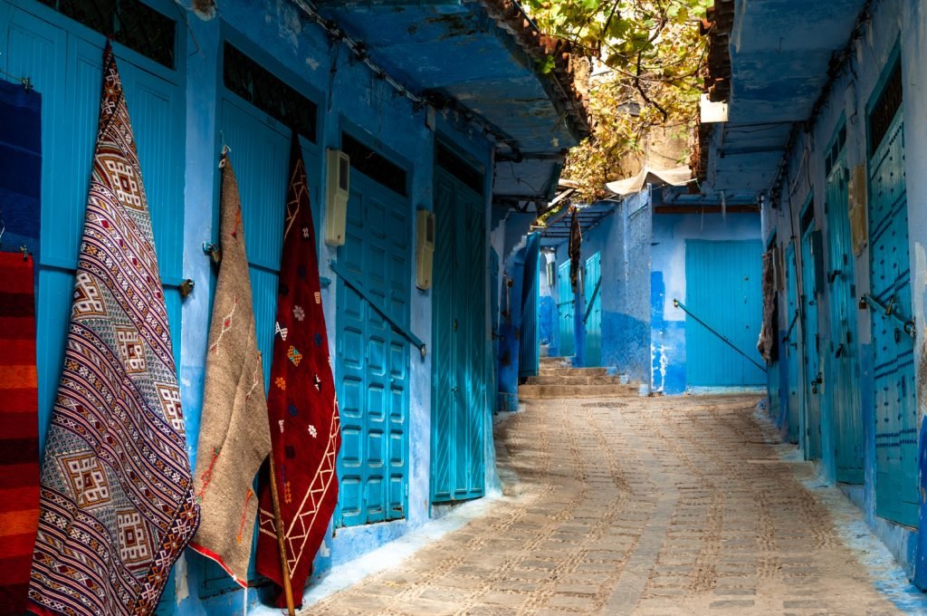 Moroccan rugs hanging in Medina Streets of Chefchaouen Morocco