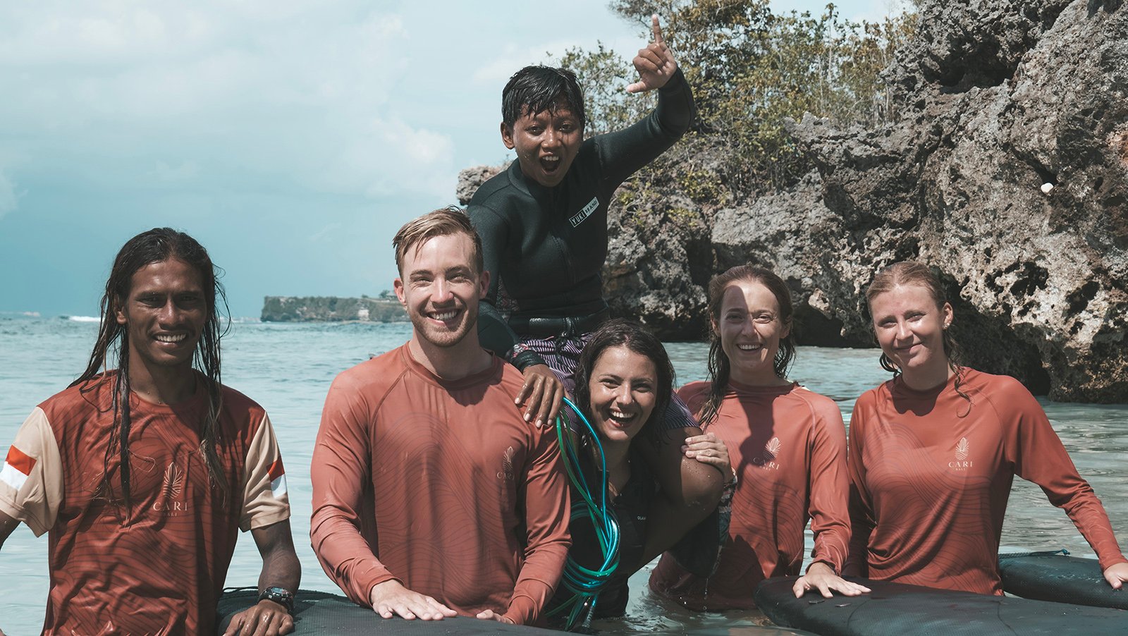 group of surfer students wiht surf instructors in the water in Indonesia with cari surf camp Bali