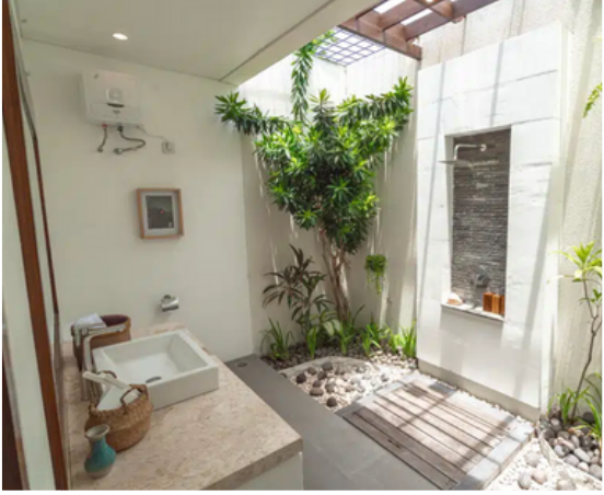 outdoor fresh but private shower in cari surf camp Bali in Indonesia with plant wood and white clean decor