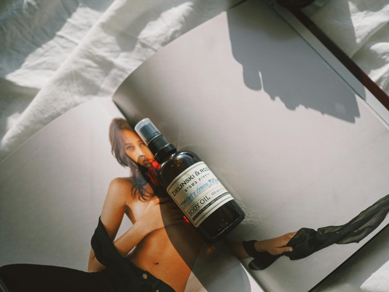 brown bottle with body oil on a magazine