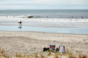 Surfer walking on Rockaway Beach, Queens, NY, USA. Photo by Hayley Pfizer