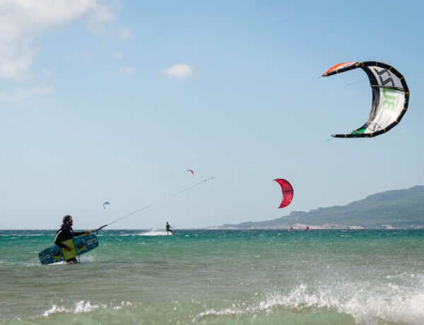 Kitesurfer in Tarifa with Kite in air and kiteboard in hand